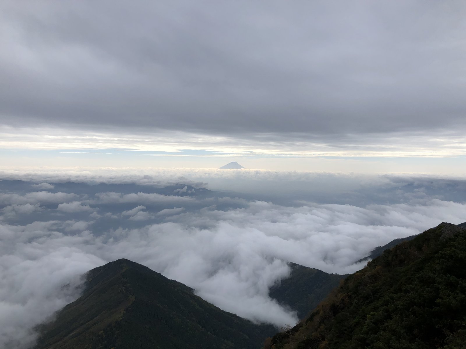 赤岳山頂から見た雲海と、その上に小さく頭を出す富士山 曇り空の南八ヶ岳 ヤマカルテ