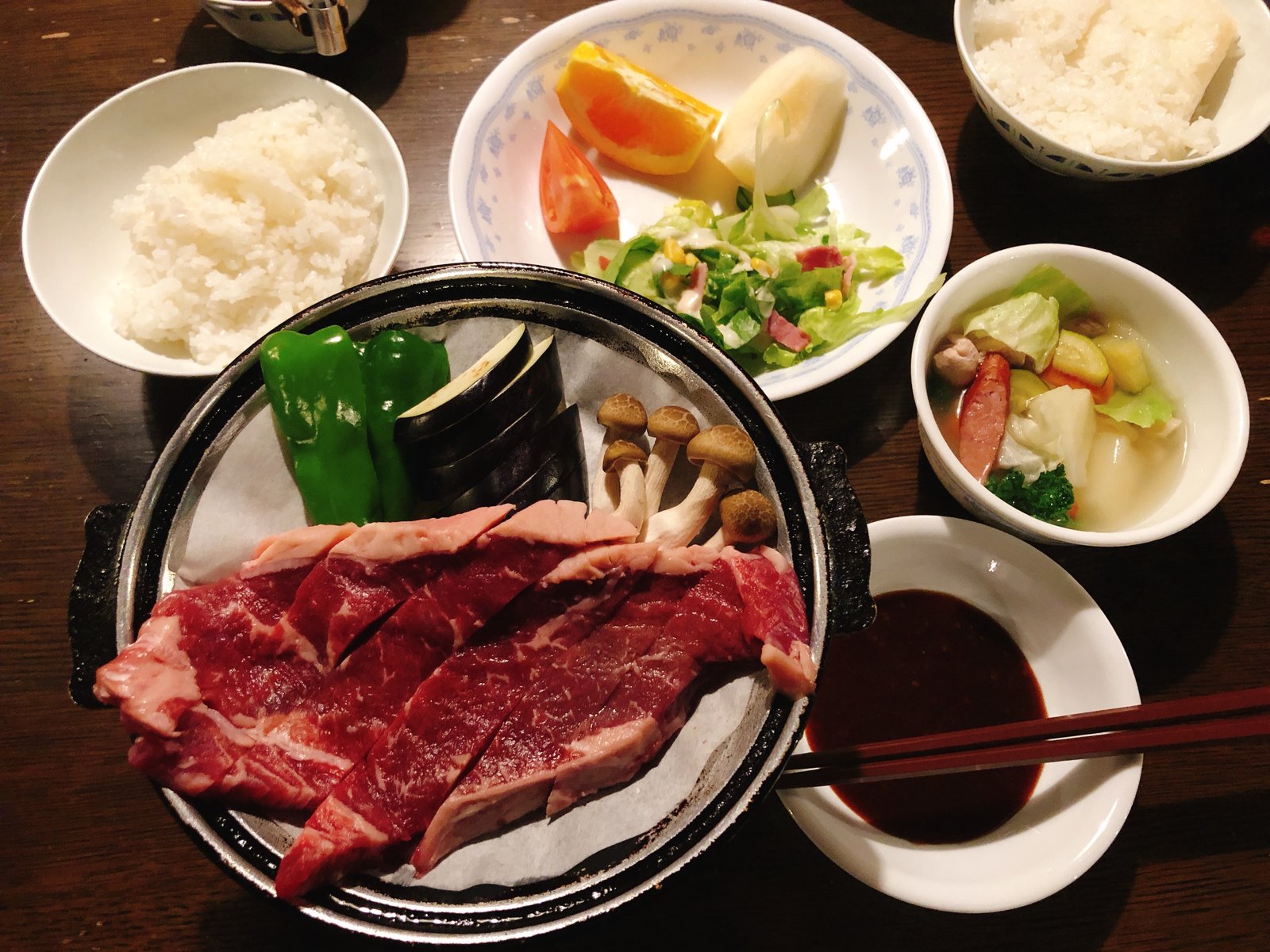 赤岳鉱泉の夕食 陶板にのった焼く前のステーキとサラダ・果物・ごはん ヤマカルテ