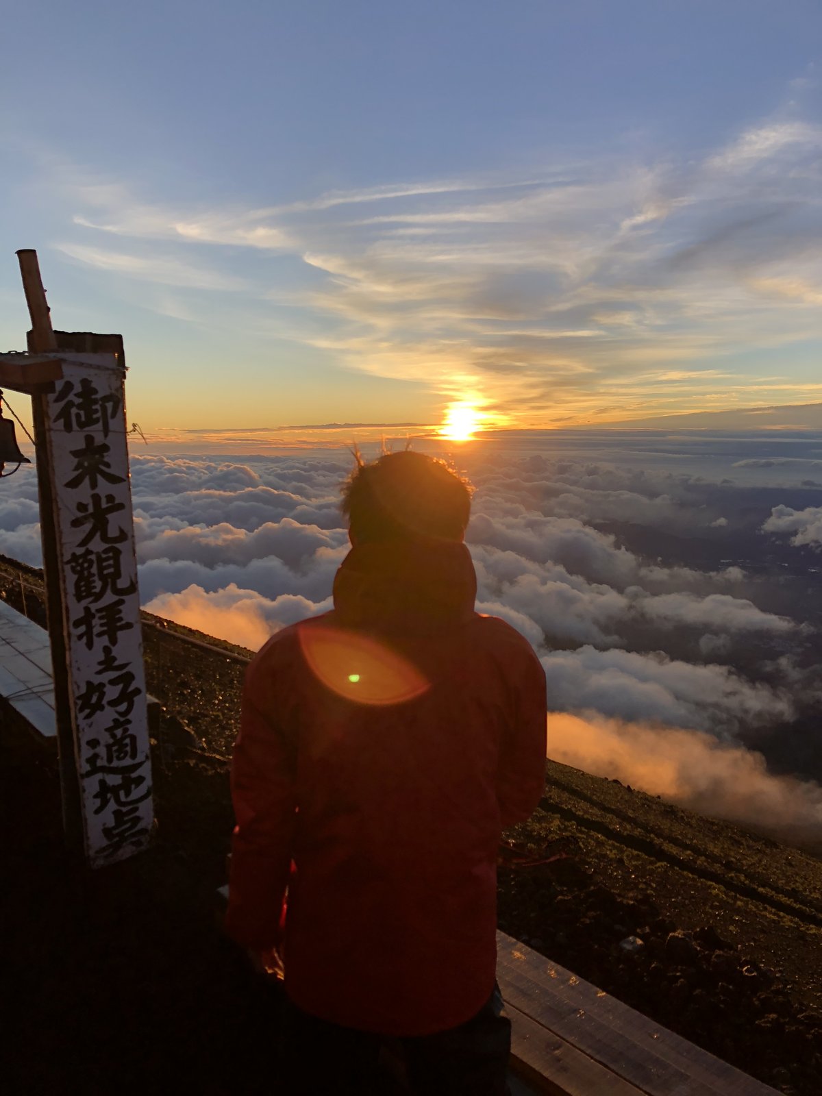 富士山8合目のご来光と防寒着の登山者 停滞時の冷え対策