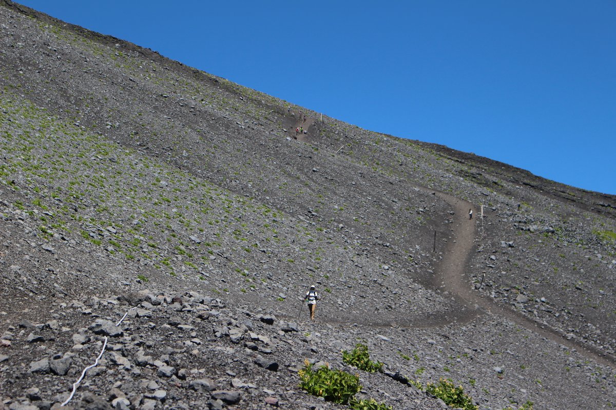 誘導ロープに沿って砂礫の下山道を下る登山者 富士山の砂走り