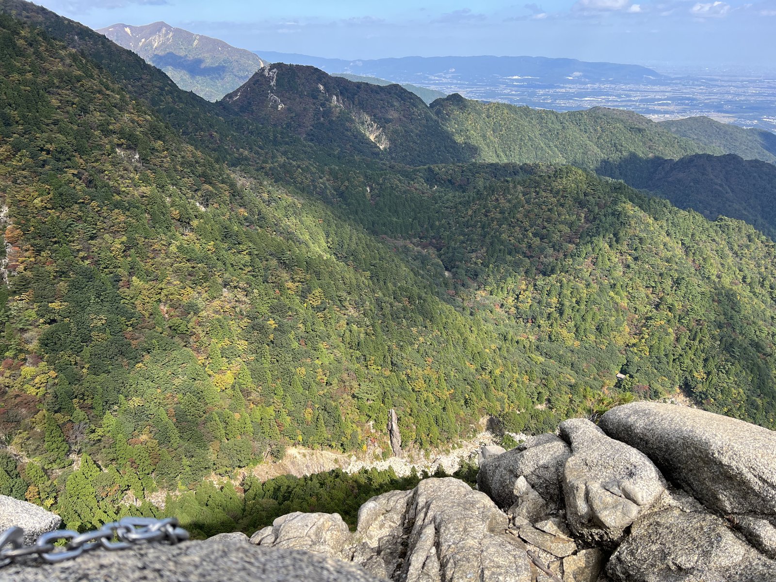 最後の岩壁の上から見下ろした谷と鈴鹿の山並み 遠くに広がる平野 御在所岳ヴィアフェラータ ヤマカルテ