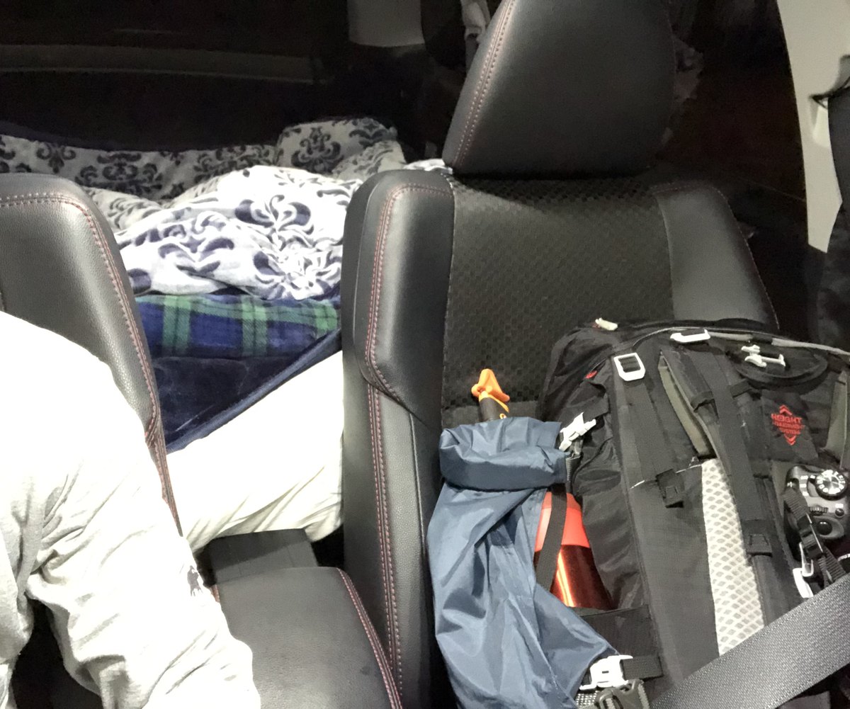 登山口での車中泊の寝床 後席を倒してフラットにし毛布を敷いた車内 足元に登山用ザックとカメラ