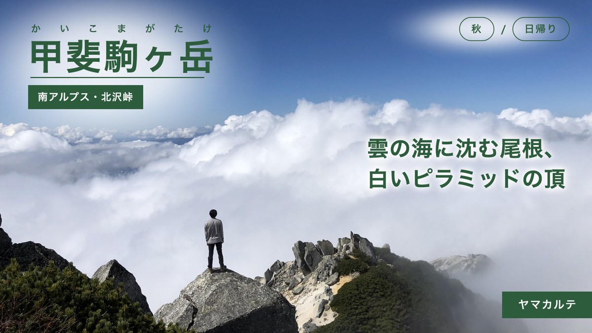 雲海に沈む黒戸尾根を前に山頂の岩に立つ 甲斐駒ヶ岳を北沢峠から日帰り 南アルプス ヤマカルテ