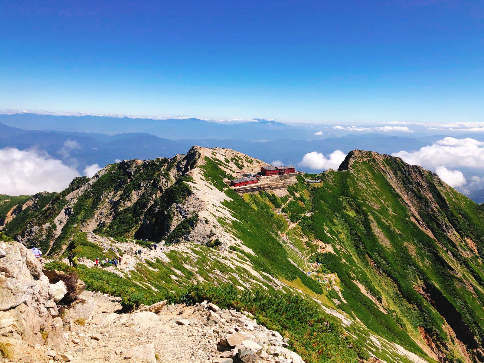 唐松岳山頂から見下ろす唐松岳頂上山荘の赤い屋根とテント場 ヤマカルテ