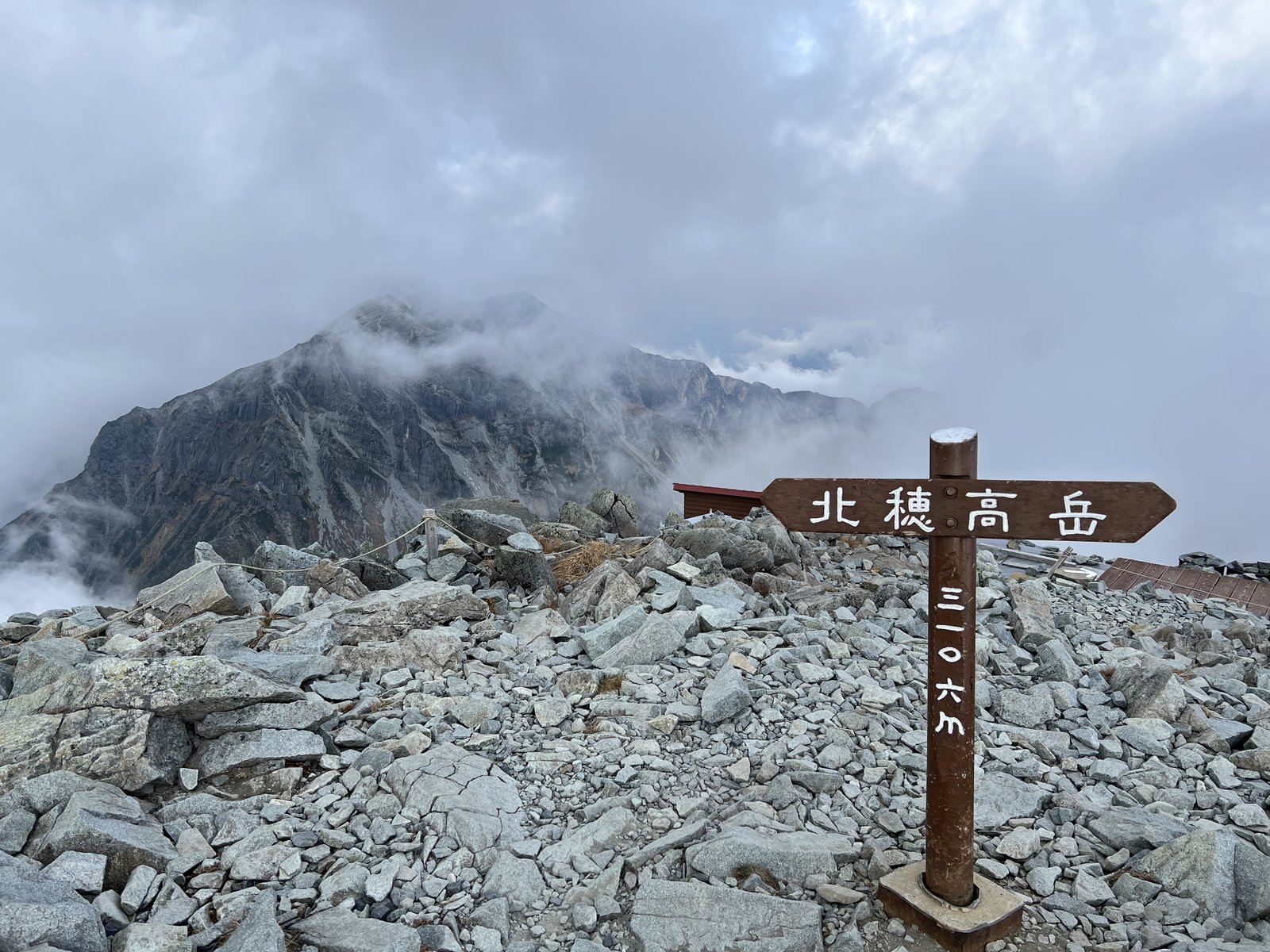 北穂高岳北峰の道標 ガスに包まれた山頂