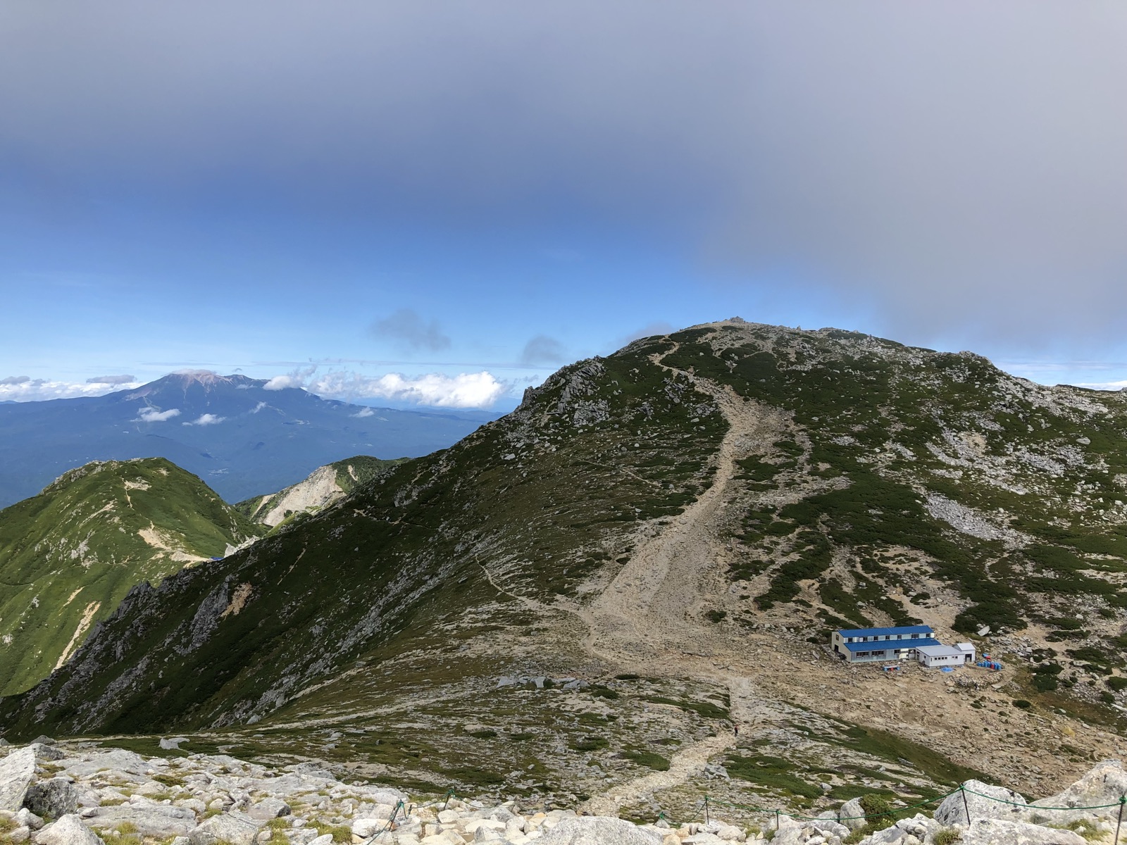駒ヶ岳頂上山荘の青い屋根と木曽駒ヶ岳山頂 中央アルプスの稜線