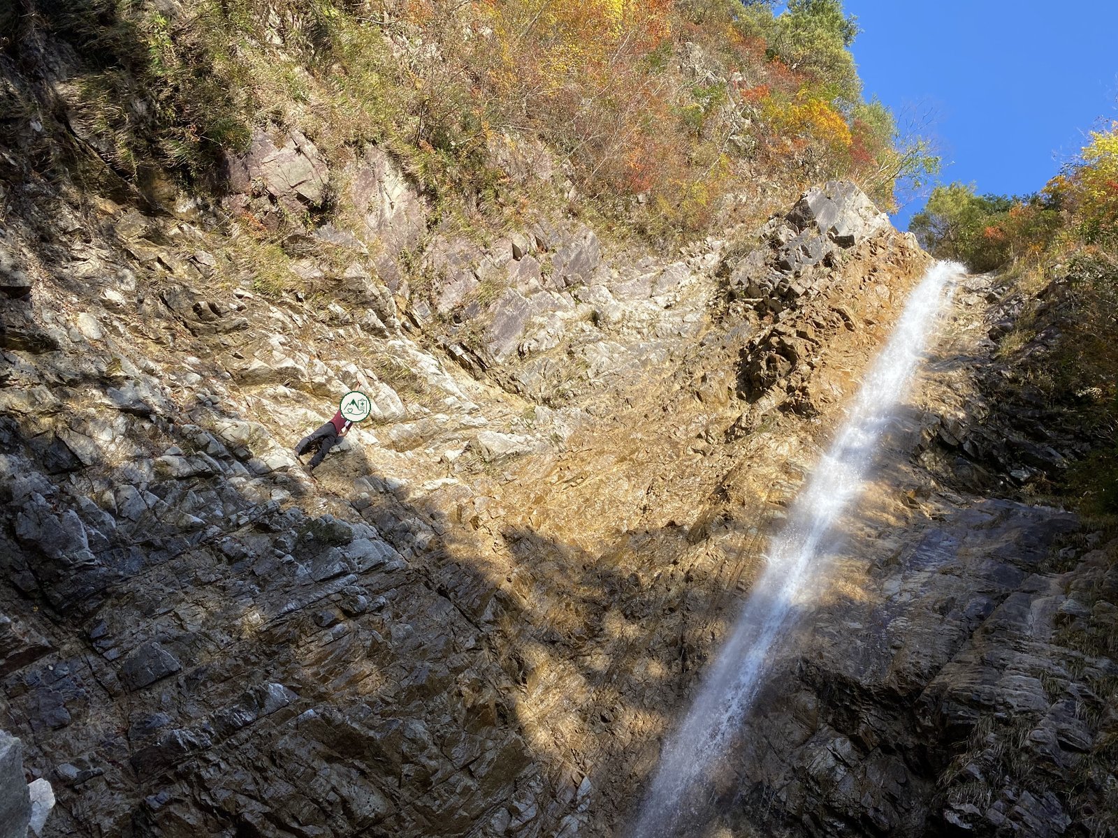 釈迦ヶ岳 庵座の大滝の横の岩場を登る筆者 紅葉の時期 2019年11月撮影 ヤマカルテ