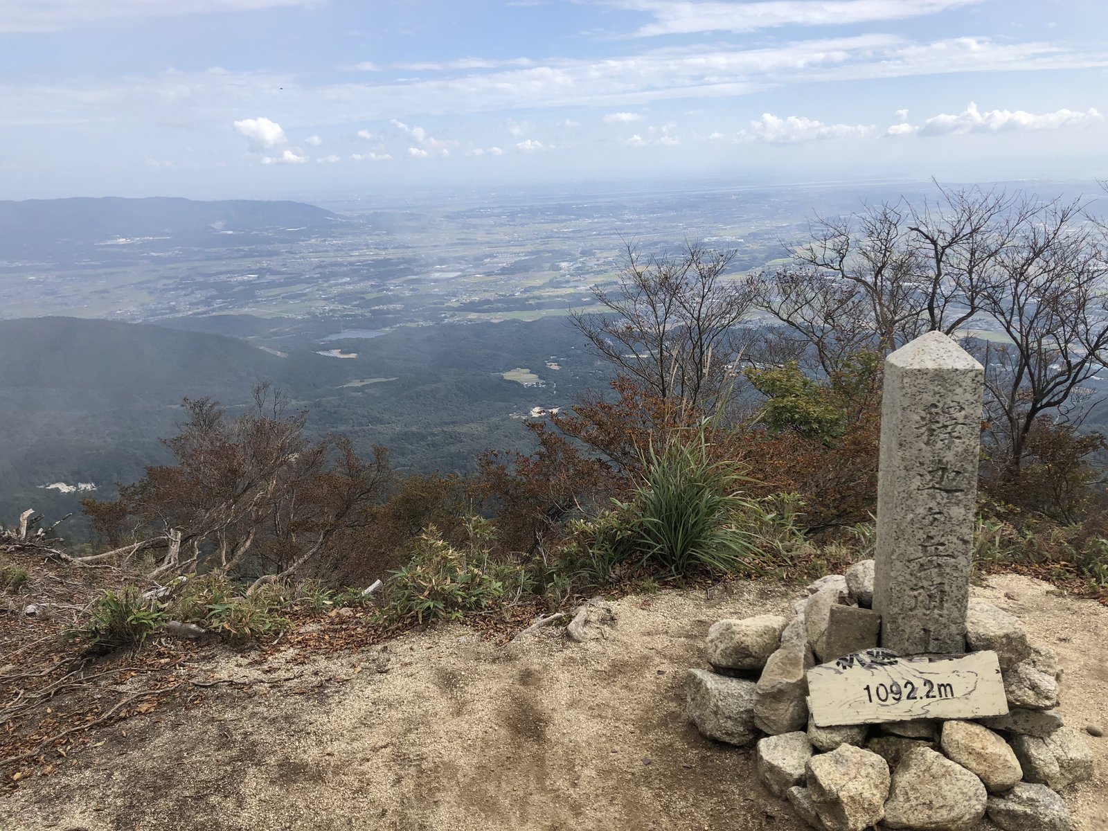 釈迦ヶ岳の山頂 三角点の石柱と1092.2mの標識 奥に広がる濃尾平野 ヤマカルテ