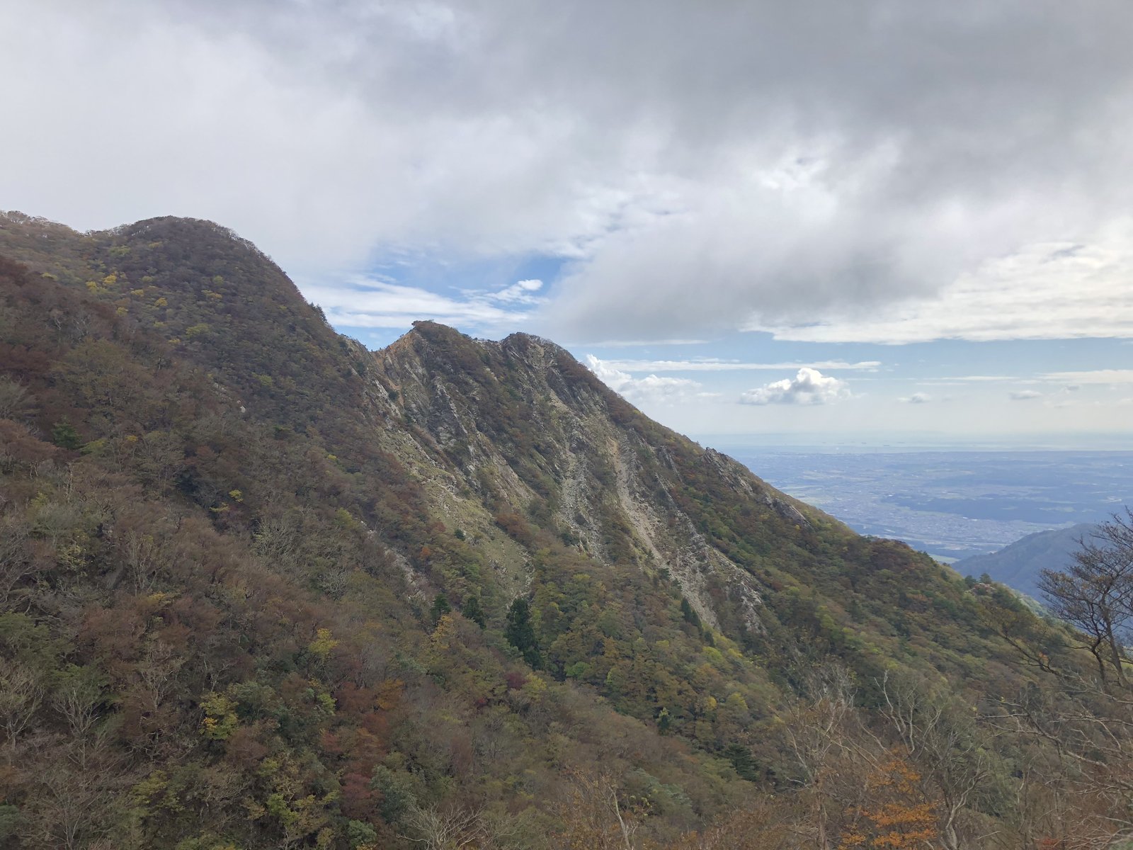 釈迦ヶ岳の稜線から引きで見た中尾根の岩稜とキレット 庵座谷から登った西側の斜面 ヤマカルテ