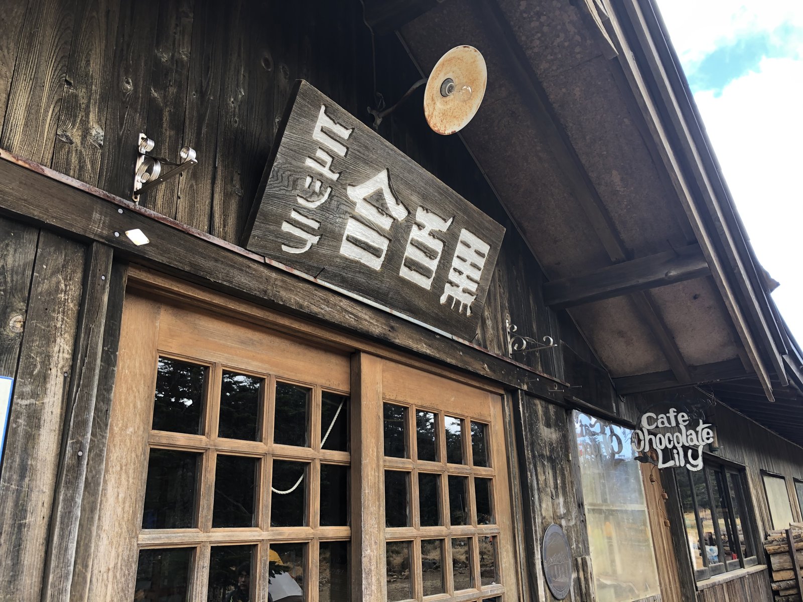 黒百合ヒュッテの看板とカフェ Chocolate Lily の入口 北八ヶ岳の山小屋 ヤマカルテ