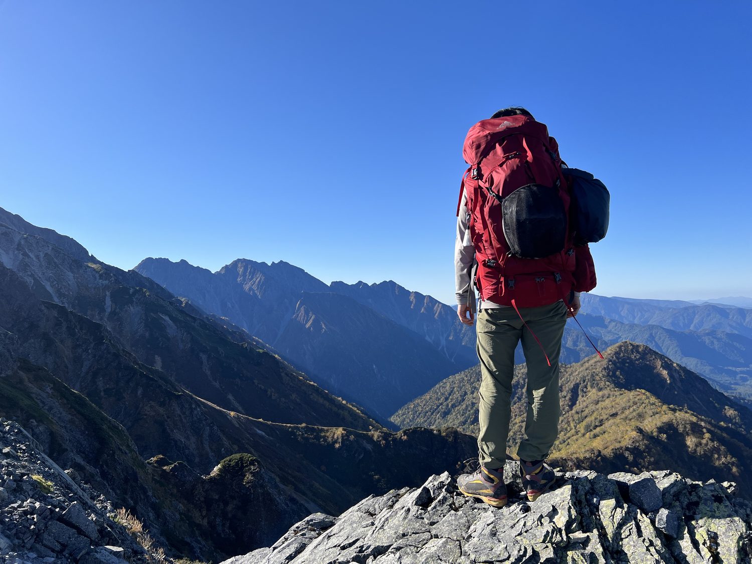 西鎌尾根を槍ヶ岳へ向かって歩く登山者のバックショット