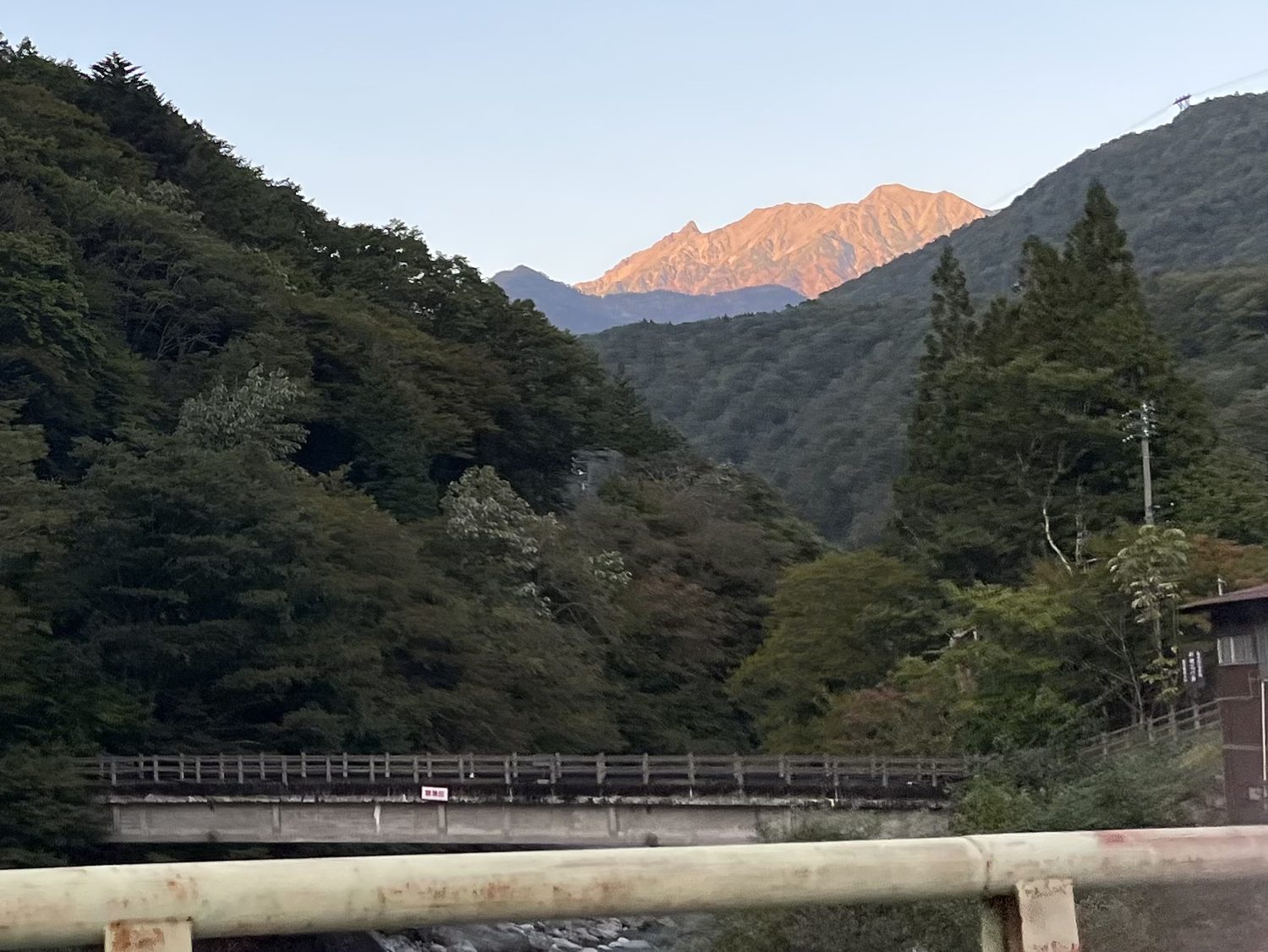 車窓から見た夕日に染まる槍ヶ岳 下山後の帰路