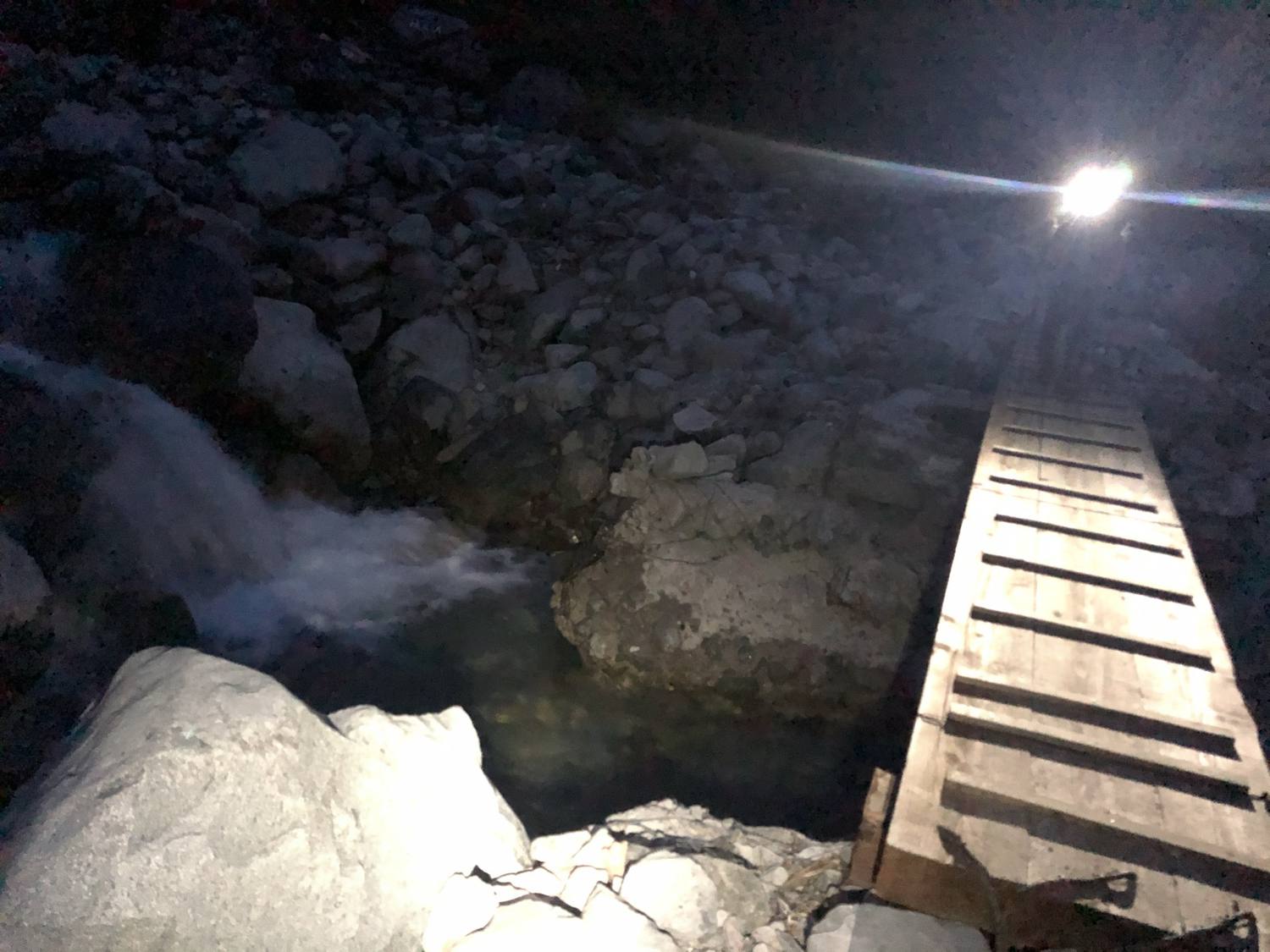 ヘッドライトの灯りに浮かぶ木橋 日没後の小池新道を下る